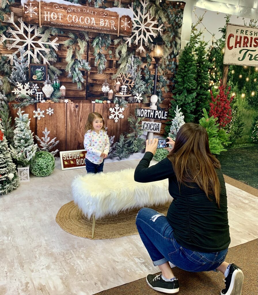 Image shows a mom taking a holiday photo of her daughter at the Selfie Stroll, one of Prescott's Christmas events.