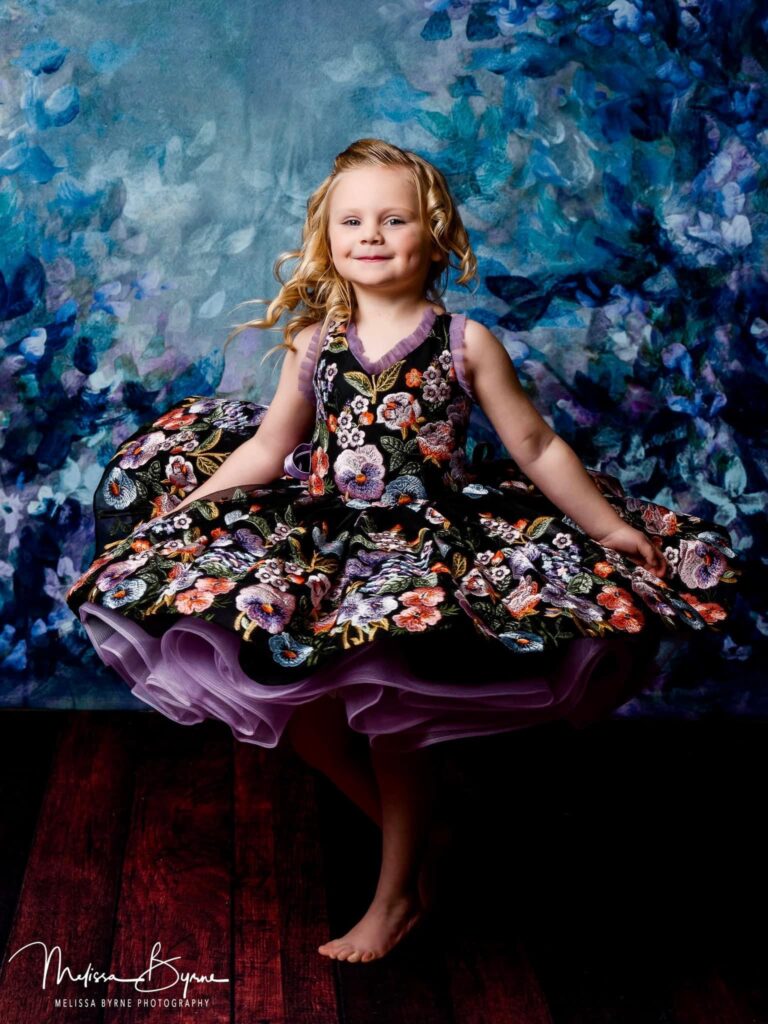 A young girl twirls in a beautiful dress. Melissa Byrne Portrait Photography