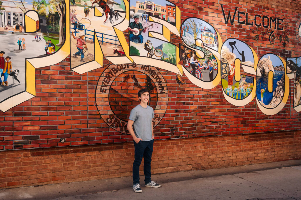High school boy posing by the downtown mural in a senior photography in Prescott, AZ. session by Melissa Byrne Portrait Photography.