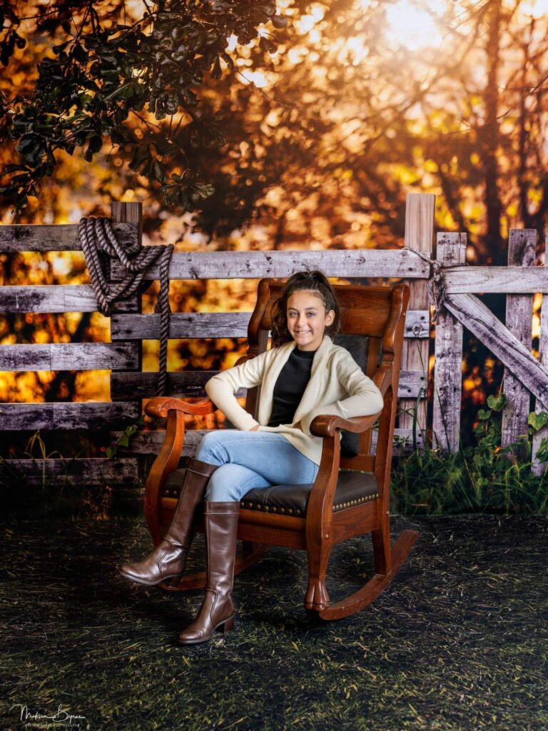 Young girl relaxing in rocking chair in a beautiful Fall western scene.